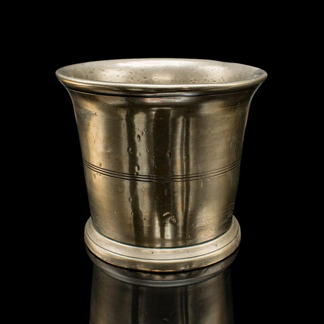 This is an antique mortar and pestle set. An English, bronze apothecary or chemist’s grinding aid, dating to the mid...