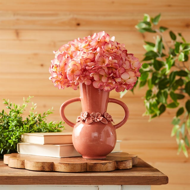 Bring soft elegance to your space with the Stoneware Vase with Floral Accent. Featuring soft mauve pink tones and a shiny...