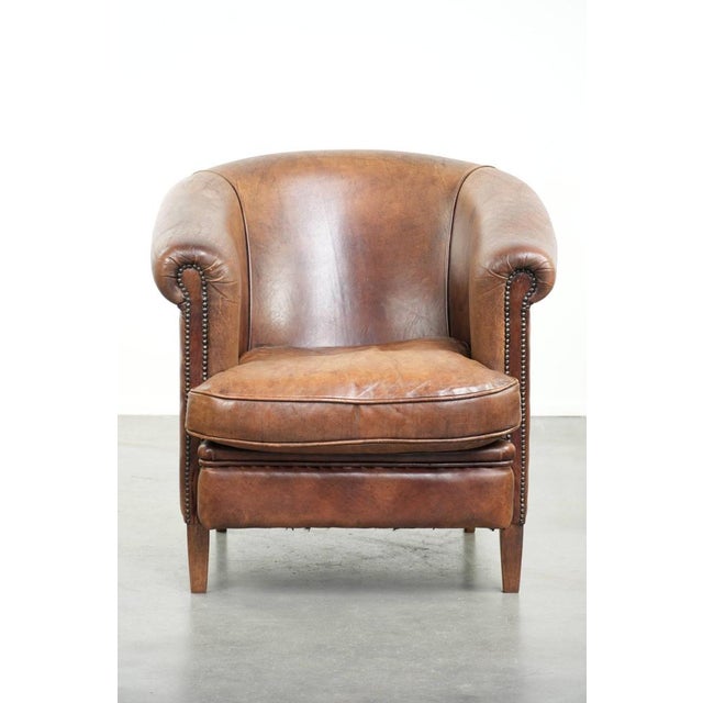 This delightful, sturdy club armchair in cognac-colored sheepskin has a beautiful vintage look in English style and...