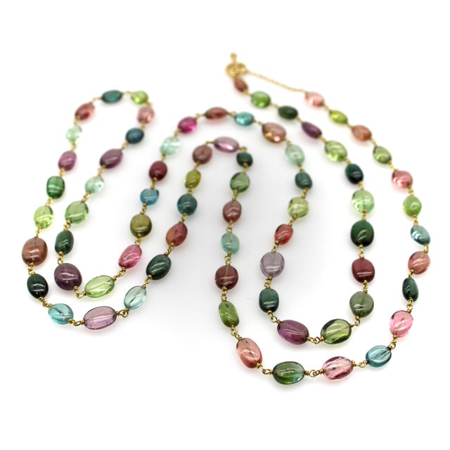 This 18k gold Syna necklace is compromised of luminous tourmaline beads in an array of colors, held together by hand-...