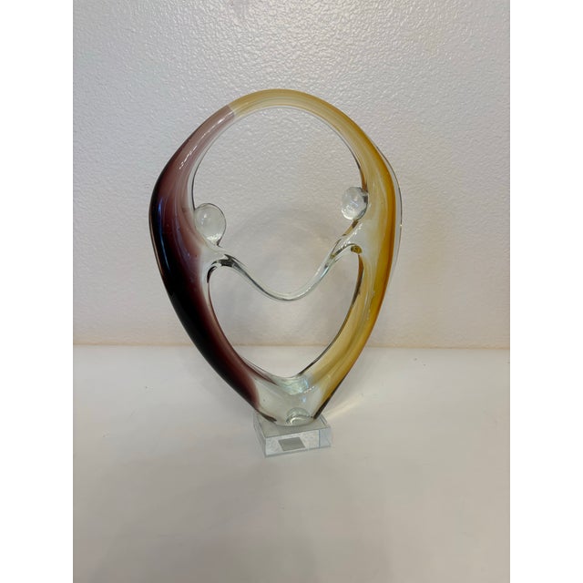 This Diamond Star Corp Murano style dancing couple sculpture featuring brown and amber glass accents. It was made in...