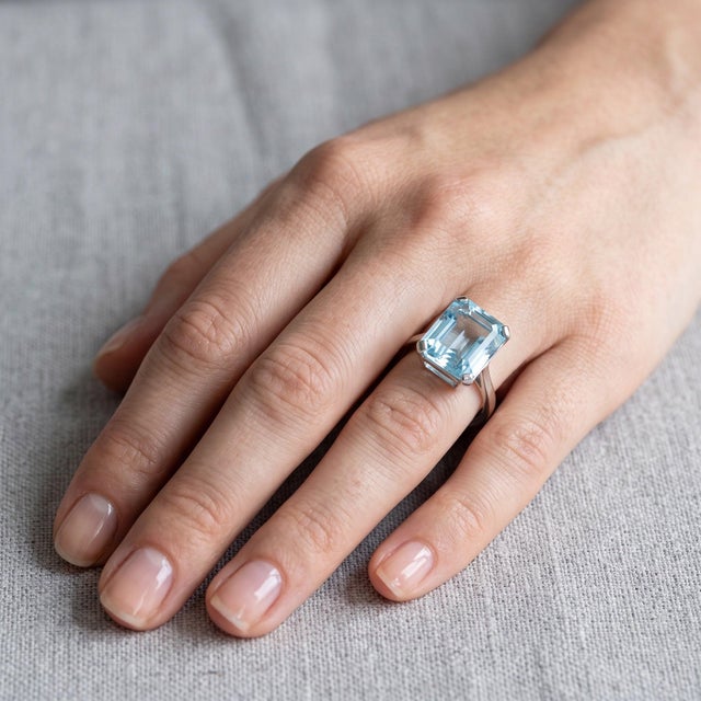 A Mid-Century platinum ring from circa 1950, centered on a natural aquamarine of approximately 7 carats — a stone of...
