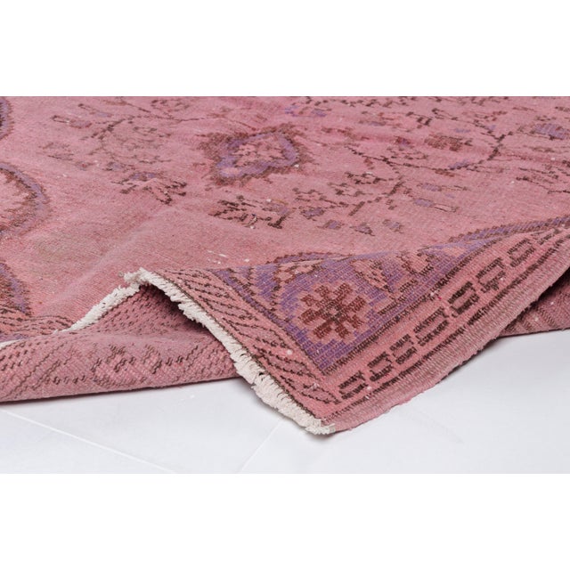 This is a vintage Turkish Oushak rug from the Mid 20th Century. The piece was hand-knotted.