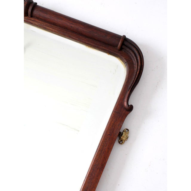 An antique Art Nouveau wall mirror distinguished by its elegantly shaped wood frame and beveled glass. Sculptural curves...