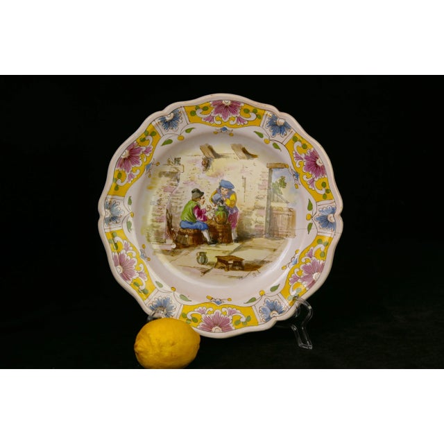 From the potteries of Lille France in the late 19th century, a transferware and hand-pained faience earthenware plate...