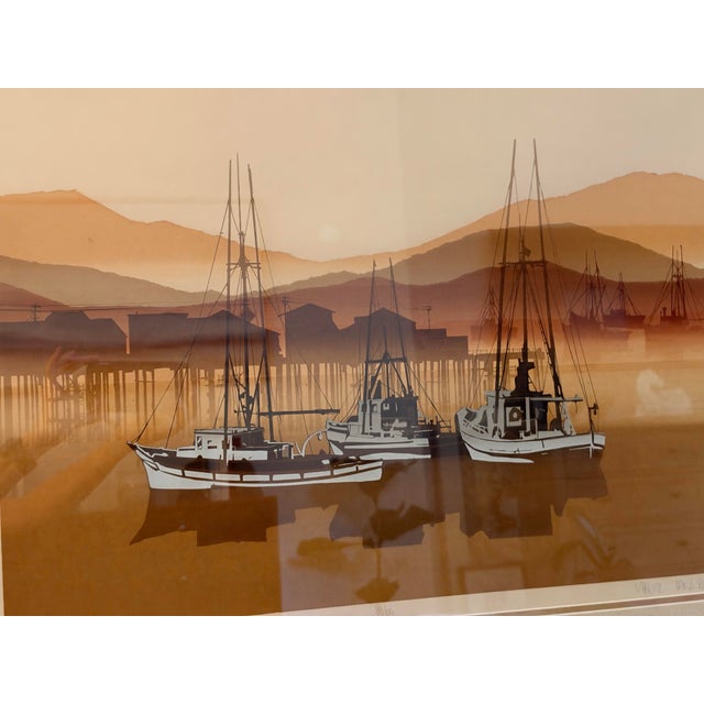 A serene sepia-toned lithograph of fishing trawlers at rest in a misty harbor, layered mountains fading behind them....