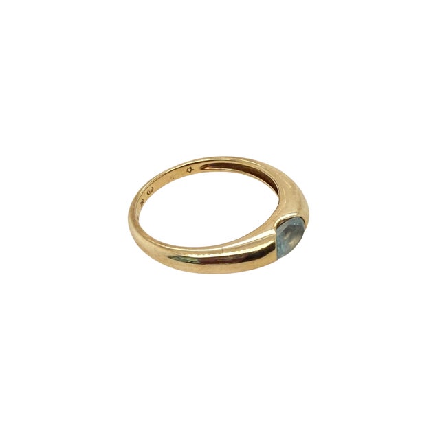 A refined H. Stern ring in 18 karat yellow gold, featuring an oval faceted aquamarine on a gently tapered band with a...