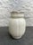 Set of two matte white glaze art deco pottery vases. The taller one is attributed to Camark with the remnants of the...