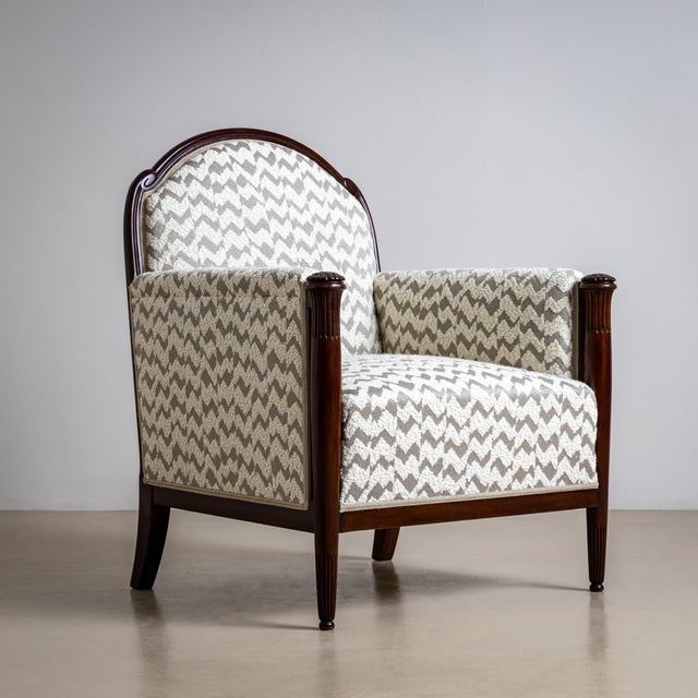 A pair of elegant Art Deco armchairs, likely from France, dating to around 1920. The rounded backrests and straight,...