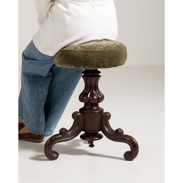 A charming late 19th century piano stool featuring an adjustable swivel seat. The design combines practicality with...