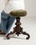 A charming late 19th century piano stool featuring an adjustable swivel seat. The design combines practicality with...