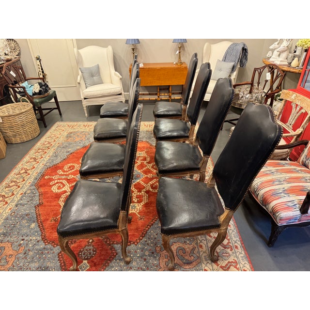 This is a set of 8 French vintage Louis XV Style Dining Chairs. They are a navy blue color. They are timelessly elegant...