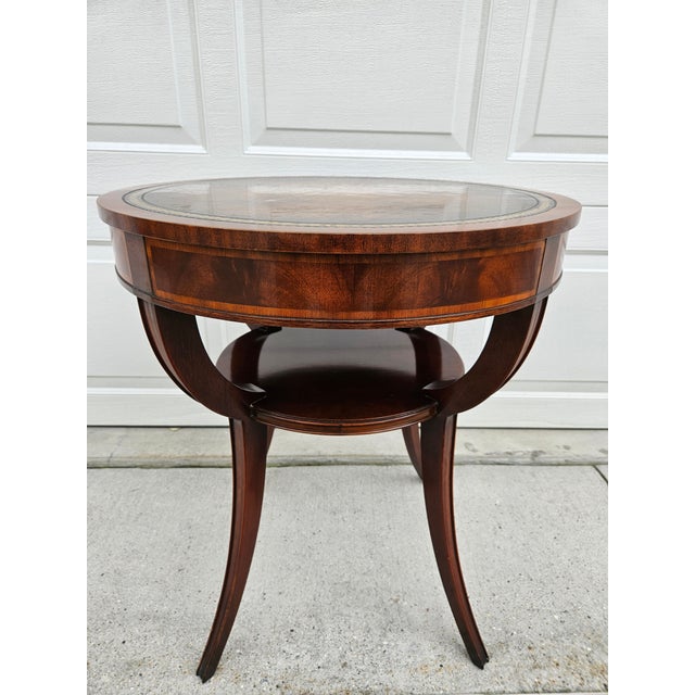 A classic round two tier mahogany and tooled leather top side table. This piece is by Weiman, so you know it is a quality...