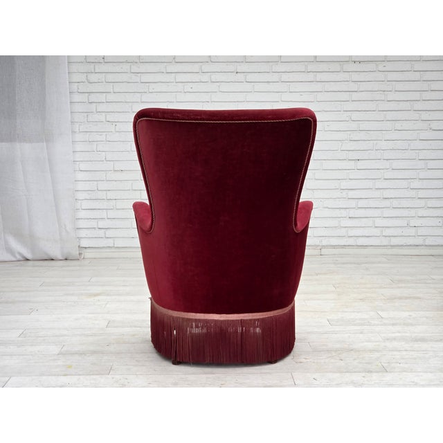 1970s, Danish armchair. Cherry-red furniture velour, ash wood legs, springs in the seat. Original good condition: no...