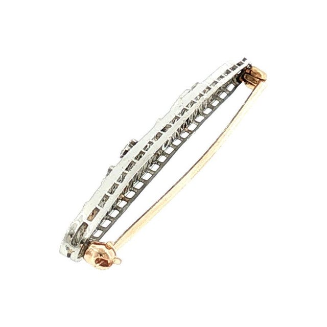 An early 20th-century platinum over 14k gold brooch featuring 9 old European-cut diamonds weighing approximately .30...
