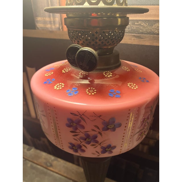 Victorian brass oil lamp converted into an electric lamp with finial and silk shade (most likely original). Pink painted...