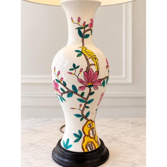 Beautiful vintage table lamp featuring a glossy white ceramic body decorated with delicate pink floral blossoms and green...