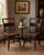 Charming pair of antique spindle-back side chairs featuring a beautifully aged dark painted finish with warm reddish-brown...