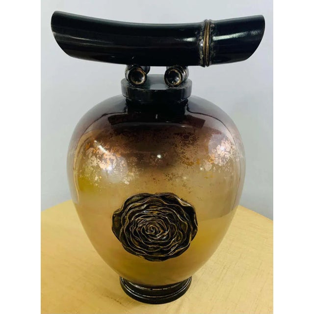 A highly decorative vintage Asian amber glass vase or lid urn. The urn features a handcrafted flower brass design in the...