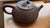 A distinctive Chinese Chaozhou zhuni red clay teapot bearing the impressed seal 章燕城制, translating to “Made by Zhang...