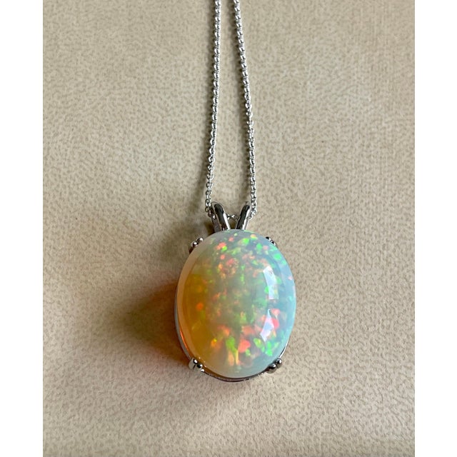 Approximately 40 Carat Oval Ethiopian Opal Pendant / Necklace 14 Kt white Gold Necklace with Chain This spectacular...