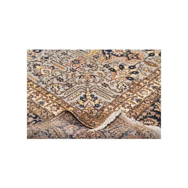 This traditional handwoven Persian Tabriz style area rug features an intricately rendered medallion and corners design...