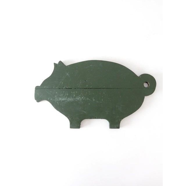 This antique primitive pig kitchen board features a charming hand-cut silhouette and a beautifully worn green painted...