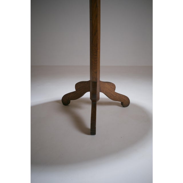 A small French side table from the early 20th century, made of solid wood, likely walnut. Its minimalist design consists...