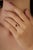 This three stone ring features a 0.6 carat oval ruby set in 18k yellow gold. The ruby measuring approximately 4.8 x 6 mm,...