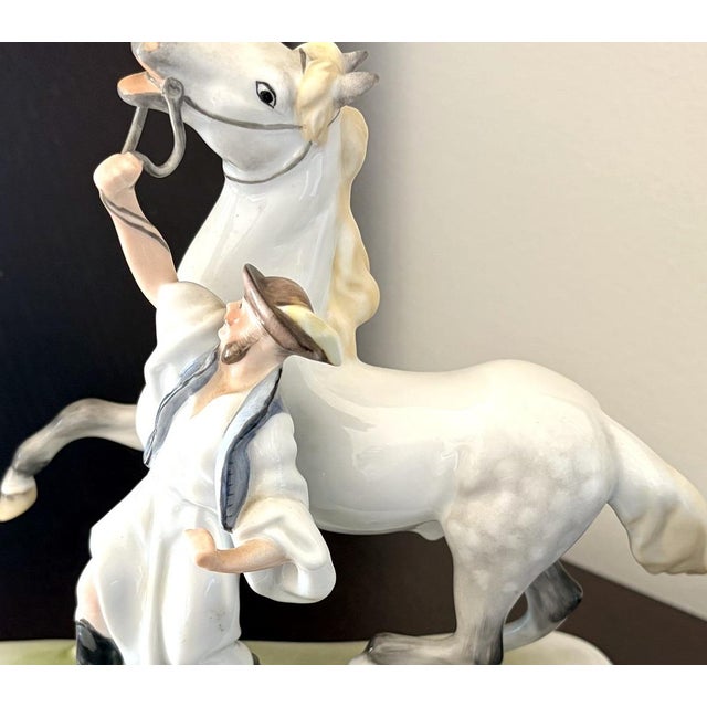 A dramatic Herend porcelain group: a Hungarian csikós, the horseman of the Great Plain, in white folk dress and wide-...