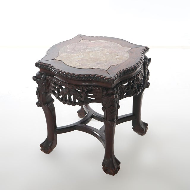 An antique Chinese low table offers rosewood construction with shaped picture frame marble top having beaded trim over...