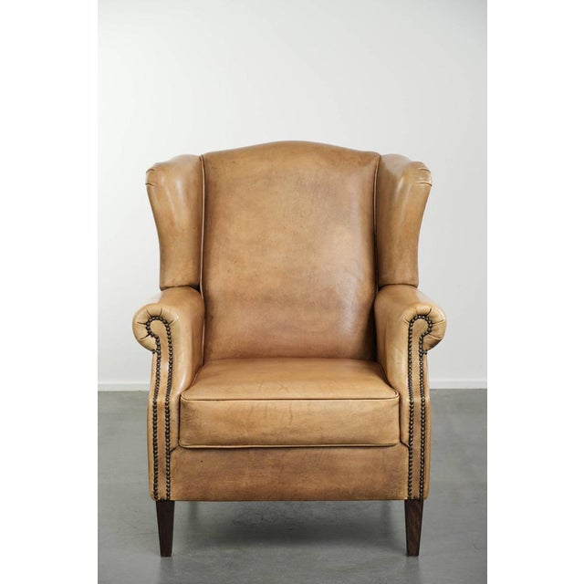 This beautiful, light-colored cowhide wingback chair has a timeless English look and offers excellent seating comfort. It...