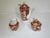 A Japanese Gold Imari porcelain tea service consisting of a tea pot, sugar and creamer. It is hand-painted in colors of...