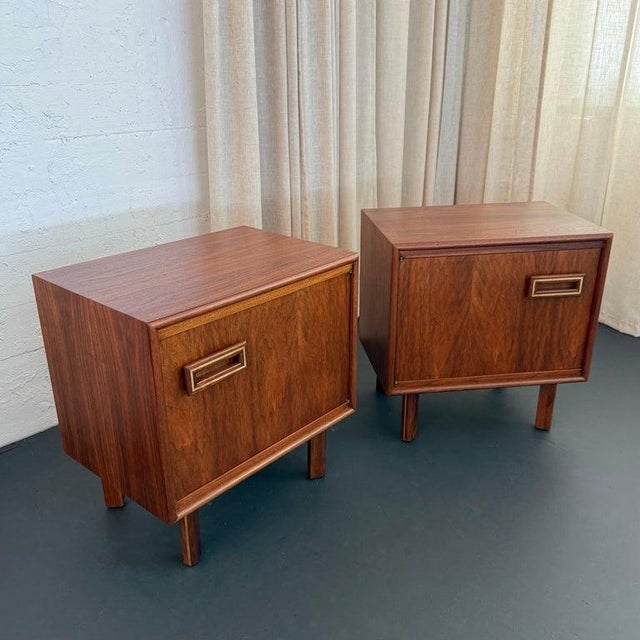 This wonderful pair of Mid-Century Modern walnut nighstands are American made circa the 1960s. The pair feature cube...