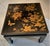 Oriental lacquered low table with drawings of flowers and butterfly in gold.