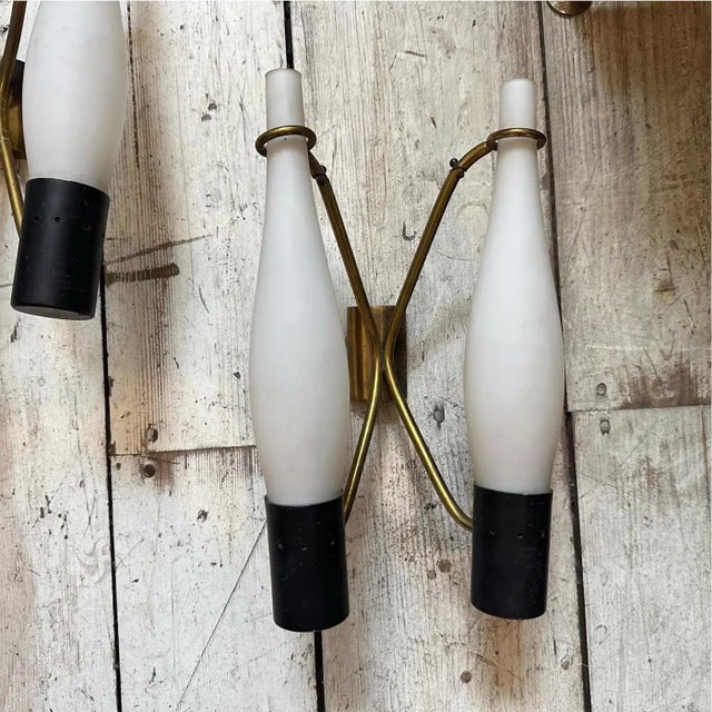 These are two Mid-Century Modern wall sconces from the 1950s, designed in the Stilnovo style, an Italian manufacturer...