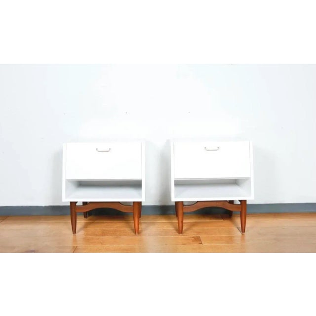 Gorgeous refinished pair of American of Martinsville nightstand. Has metal handles. Has been painted in white with...