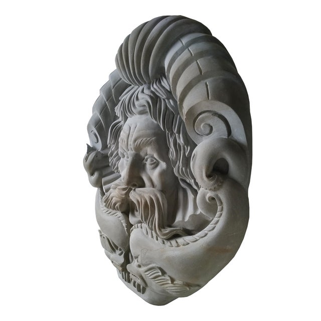 A majestic light gray limestone Triton mask spout, inspired by the classic representation of the Greek myth, hand carved...