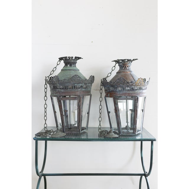 A striking and sculptural pair of antique French copper lanterns, beautifully aged to a rich verdigris patina that speaks...