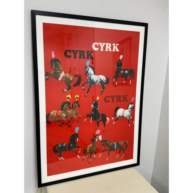 Design Plus Gallery presents a Cyrk Polish Poster Print by Waldemar Świerzy. This print presents a vivid red composition...