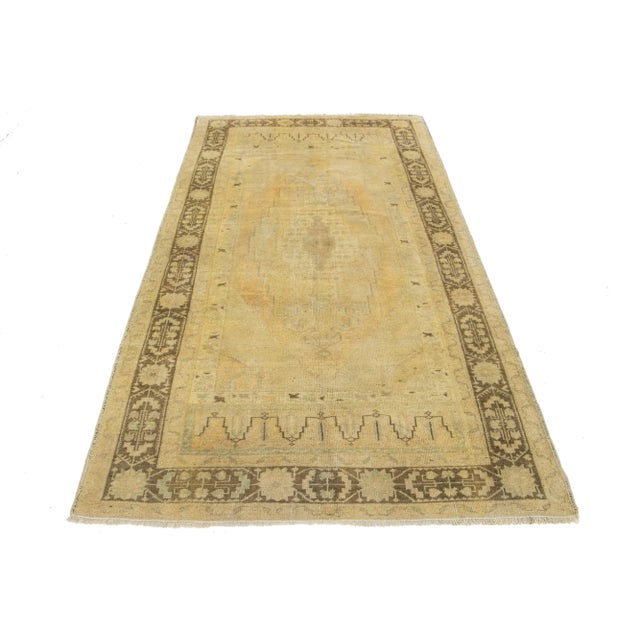 Beautiful Antique Turkish khotan hand-knotted wool rug with a beige field. This Khotan has brown and light orange accents...