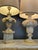 Two table lamps with stems made of carved wooden architectural elements—one in the form of a capital decorated with...
