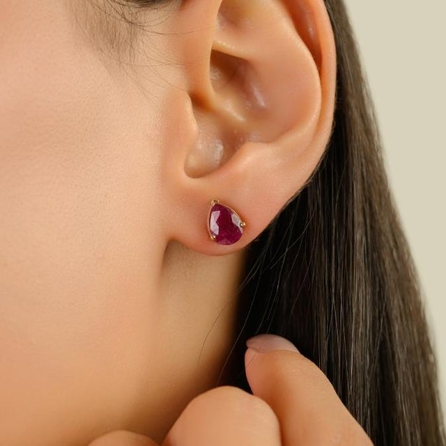 These graceful 14k yellow gold stud earrings showcase two natural pear-shaped rubies with a combined gemstone weight of...