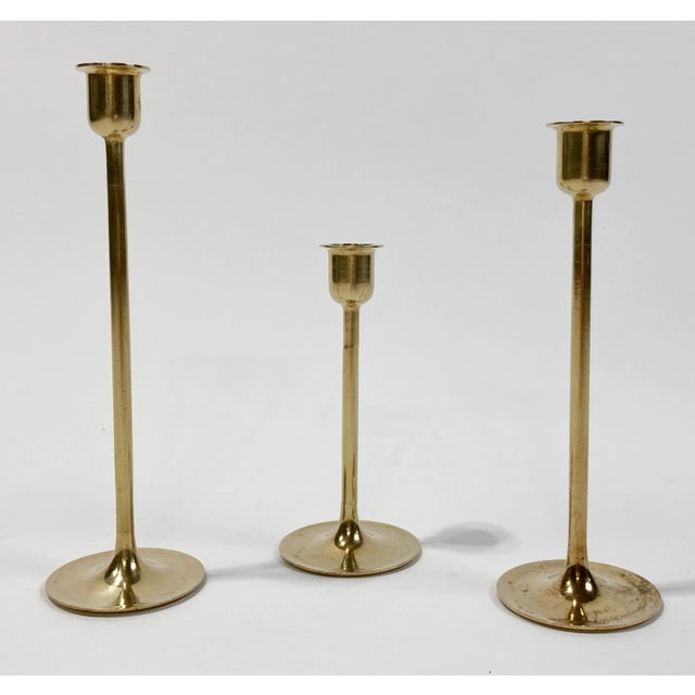 Vintage mid-century modern set of three brass tulip candlesticks with graduated heights. Tallest 9"H, shortest at 6"H....