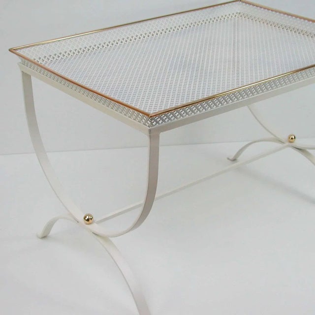 This 'Snow White' side table was produced in France in the 1950s. It is made of white lacquered perforated metal and brass...