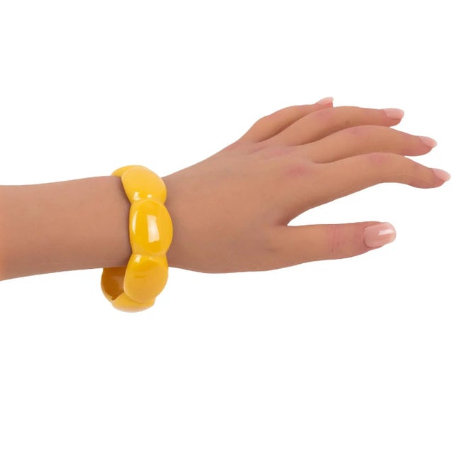 This is a superb yellow creamed corn Bakelite bracelet bangle. The piece boasts a geometric carved design with an intense,...