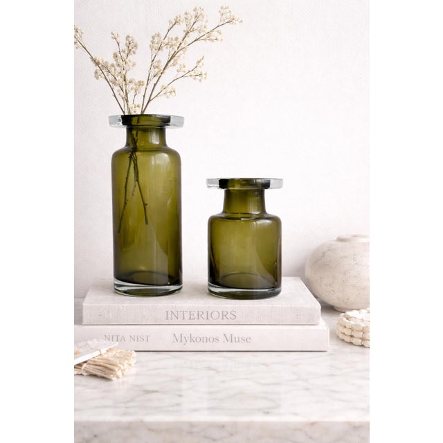 This sculptural pair of olive glass hurricane candle holders evokes the refined elegance of Italian Empoli-style art...