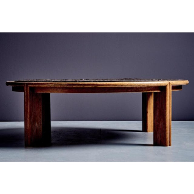 Narrow coffee table in oak with an inset slate top. A rounded oak rim frames the dark stone surface, whose natural texture...