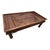 Hand-carved Indian door-panel coffee table featuring deeply carved geometric and floral-style motifs, turned wood legs,...