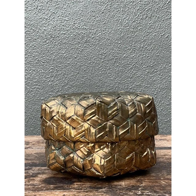 This vintage gilded rattan decorative box showcases an intriguing sculptural form, its rounded hexagonal silhouette...